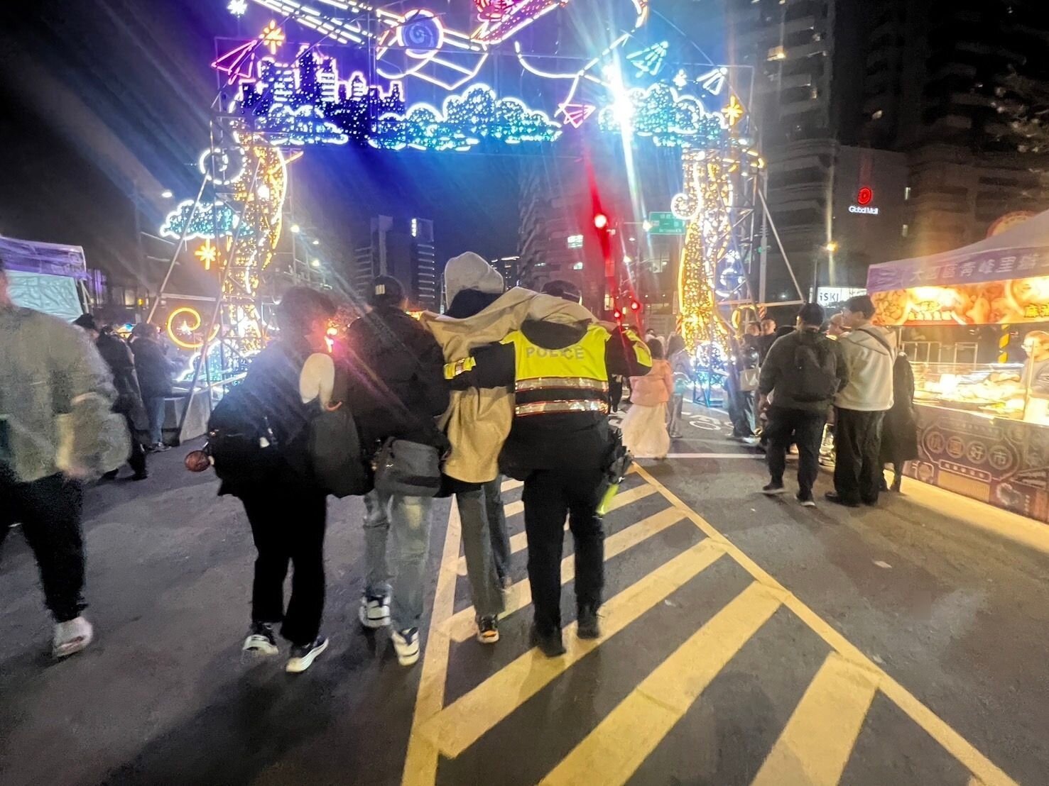 現場人潮眾多，員警主動協助將少年攙扶至車上。圖：讀者提供