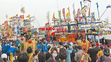 
高雄市4年舉辦1次的民俗活動「林園鳳芸宮媽祖海巡」11日巡境隊伍抵達高雄港，靠岸的漁船上裝飾鮮花、旌旗，一字排開氣勢磅礡，不少民眾拍照記錄難得景象。（紀爰攝）
