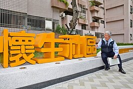 台北市副市長張金鶚開心發表懷升社區改造後成果，並與懷生社區門牌合照，對於自己辦理國宅出租計畫的成果十分滿意。（圖文／好房News記者 陳韋帆）