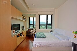 廖盈婷喜歡線條簡單的設計，因此家中以溫暖的白色、米色為主視覺。客廳有一套米白色的大沙發與佛桌，一進門可以眺望遠處的大笨山、獅頭山與新店溪美景，山勢層巒令人心曠神怡；雙十線條的造景窗，彷彿是六個大型平板電視，將好風光拼湊在一起。（文／蔚藍成風　圖／陳韋帆）