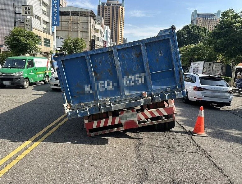 台中市英才路2日下午傳出天坑，1輛貨車行經左後輪陷下去，卡在路中間動彈不得。記者曾健祐／翻攝
