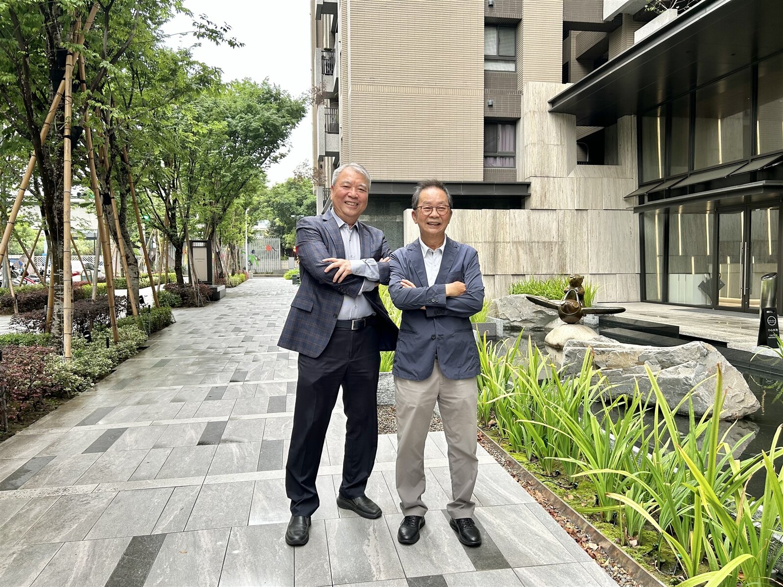 新業建設創辦人穆椿松(左)、董事長卓勝隆(右)介紹,樂業一路打通,人行道滿植花樹水綠。記者宋健生/攝影