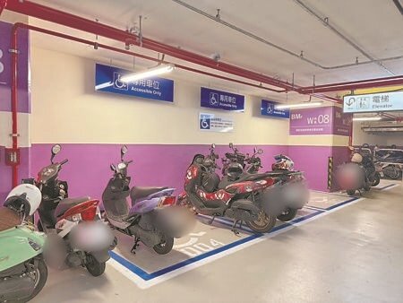 高雄車站南側地下停車場,機車違停亂象嚴重,有多輛機車占用身障車格。(紀爰攝)