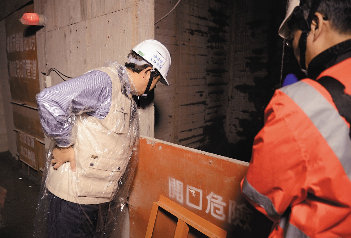 勞委會主委潘世偉(圖左)仔細檢查預設的電梯口是否有安全防護。 記者鄭超文／攝影