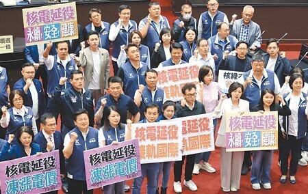 立法院13日院會三讀通過「核子反應器設施管制法」修正案,國民黨立委舉出標語並高喊「核電延役,凍漲電價」。(姚志平攝)
