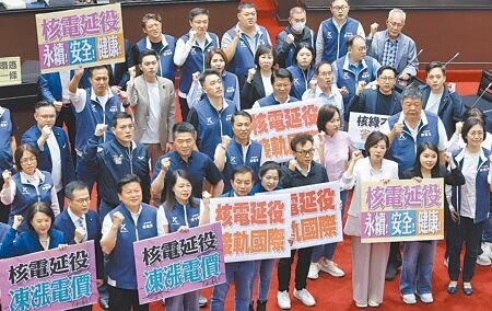 立法院13日院會三讀通過「核子反應器設施管制法」修正案,國民黨立委舉出標語並高喊「核電延役,凍漲電價」。(姚志平攝)