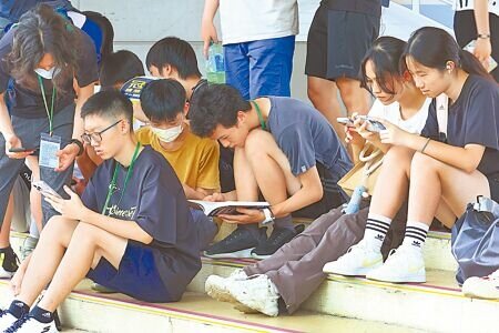 
國中教育會考18日進入第2天，台北天氣高溫難耐，休息時間考生把握機會補充水分，並抓緊時間溫習功課。（鄧博仁攝）
