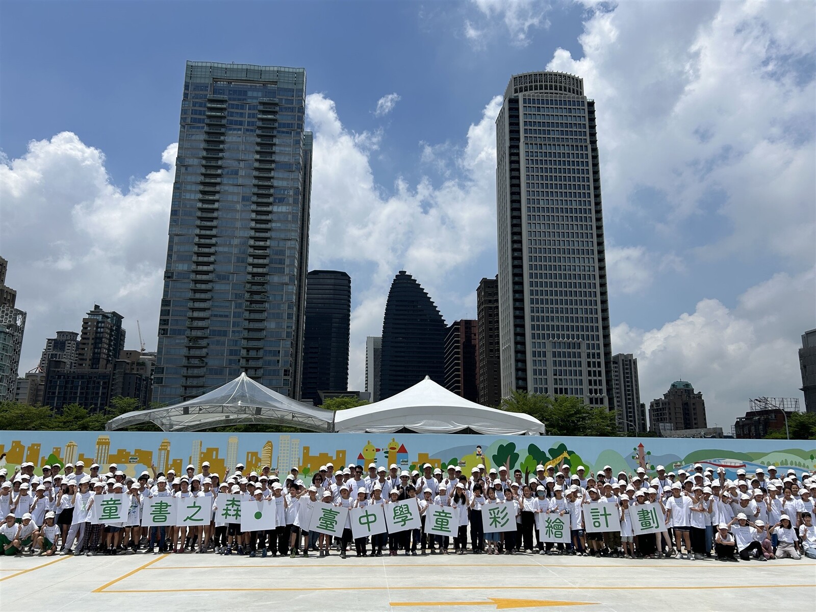 台中市政府與聯聚文教基金會昨邀逾200名學童彩繪「童書之森」72公尺長的施工圍籬。記者趙容萱／攝影 