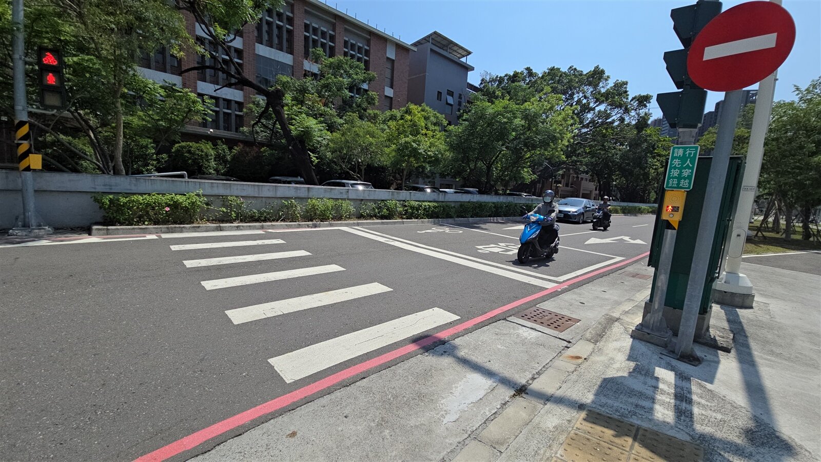 高雄三民區鐵道三街與嫩江街口設有「行人號誌請求按鈕」的設號誌行人穿越道,民眾依號誌通行,卻直通花圃與高雄中學後門圍牆,引發規畫不當爭議。記者王勇超/攝影