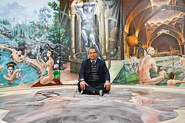 毅太企業總經理洪芳興坐在3D圖像上，享受視覺錯覺的樂趣，彷彿置身羅馬浴場中。(好房News記者 陳韋帆/攝影)