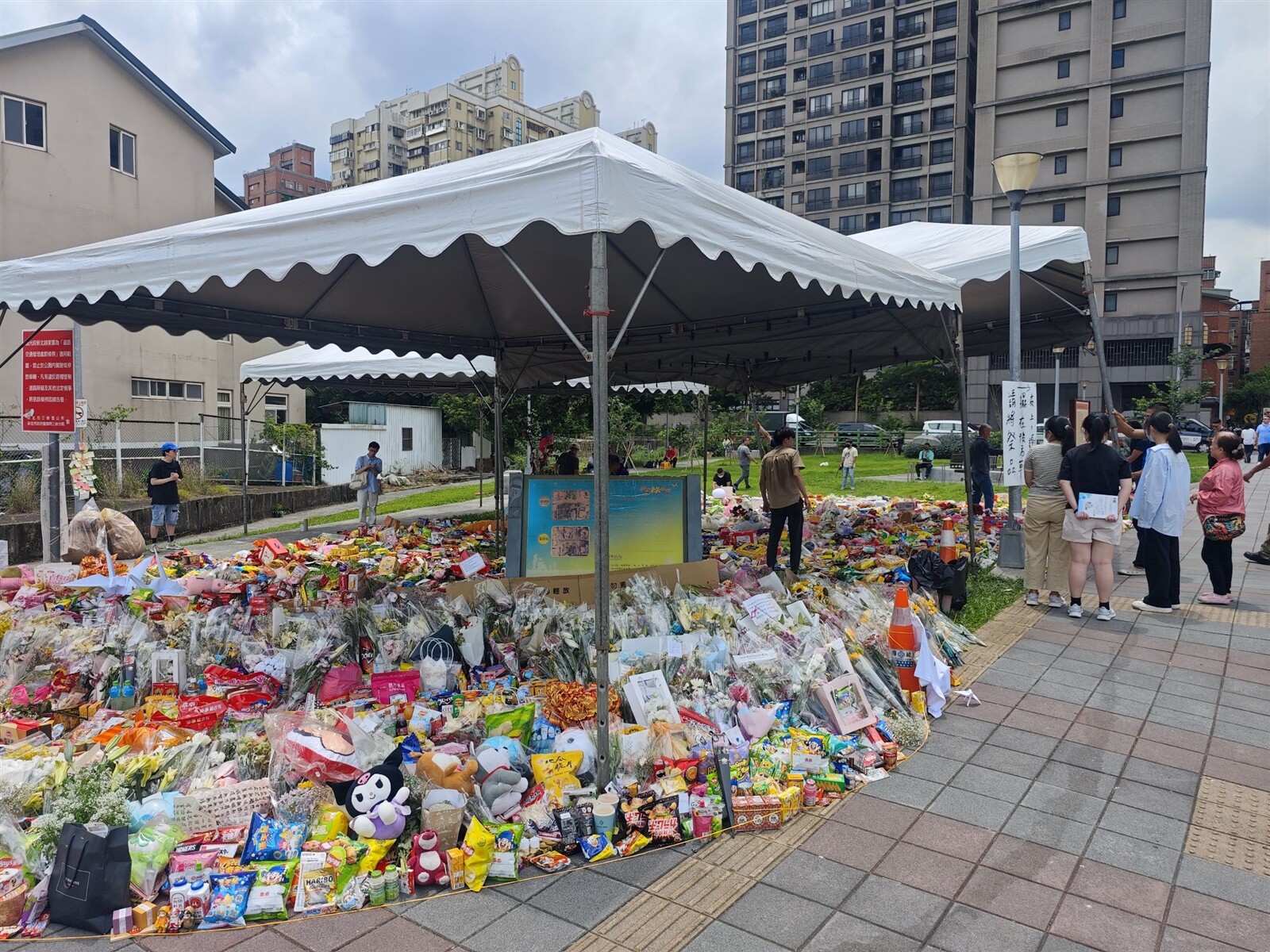 新北市三峽北大國小旁路口19日發生三死車禍，案發現場湧入民眾擺放祭品，今日已擴大至約400平方公尺面積。記者李定宇/攝影 