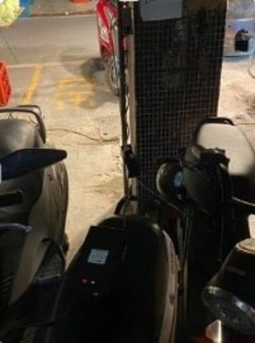 新北市議員陳世軒表示，有居民反應在無管委會的舊公寓中，樓上住戶經常從五樓垂掛延長線到一樓樓梯間，為微電車充電，現場不僅電線暴露在風雨中，且與機車緊鄰，火災風險極高。圖／新北市議員陳世軒提供