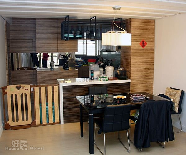 4.廚房及餐桌之間以小型吧台桌做出空間區隔,餐桌上方的造型吊燈格外醒目。