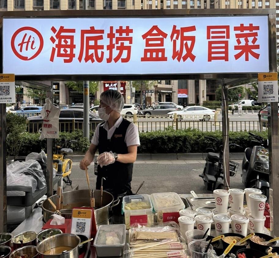 大陸網友發現,海底撈部分城市的門市員工開始將賣早餐、便當和冒菜的餐車推到街頭販賣。圖/取自小紅書