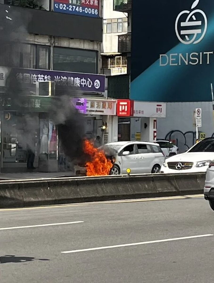 台北市信義區統一時代百貨對面，今下午有一輛汽車停放路旁時起火燃燒，消防隊獲報趕到灌救。圖／讀者提供
