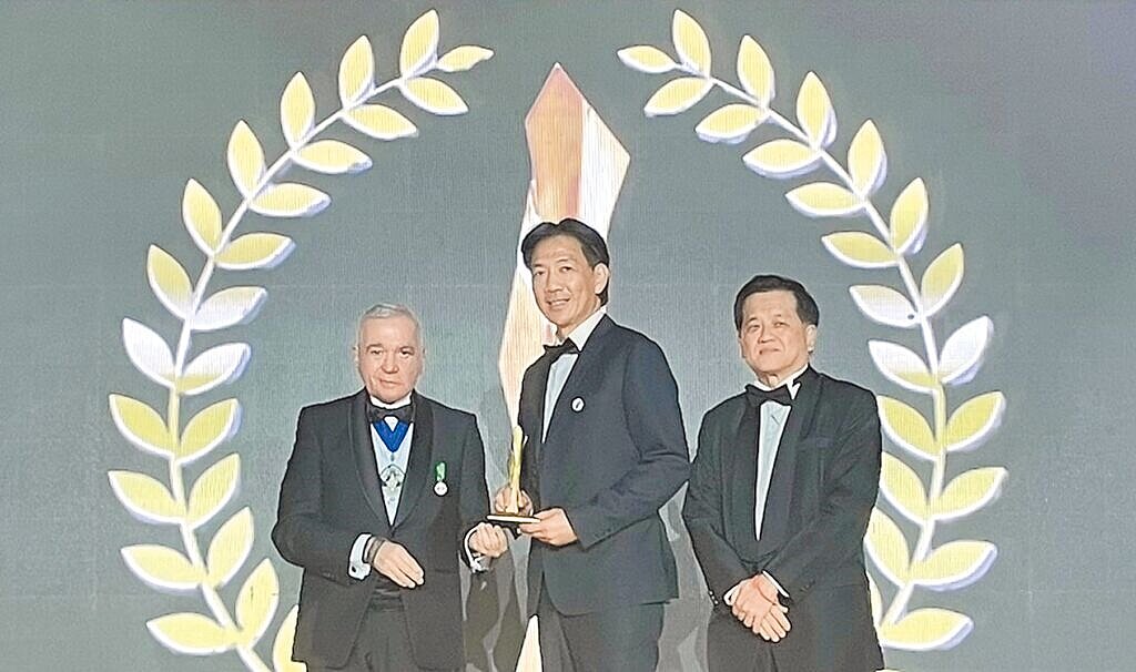 桃園中路三號社宅獲全球卓越建設獎「合宜住宅類」金獎盃,住都中心執行長邱英哲(中)12日代表領獎。(都發局提供/蔡依珍桃園傳真)