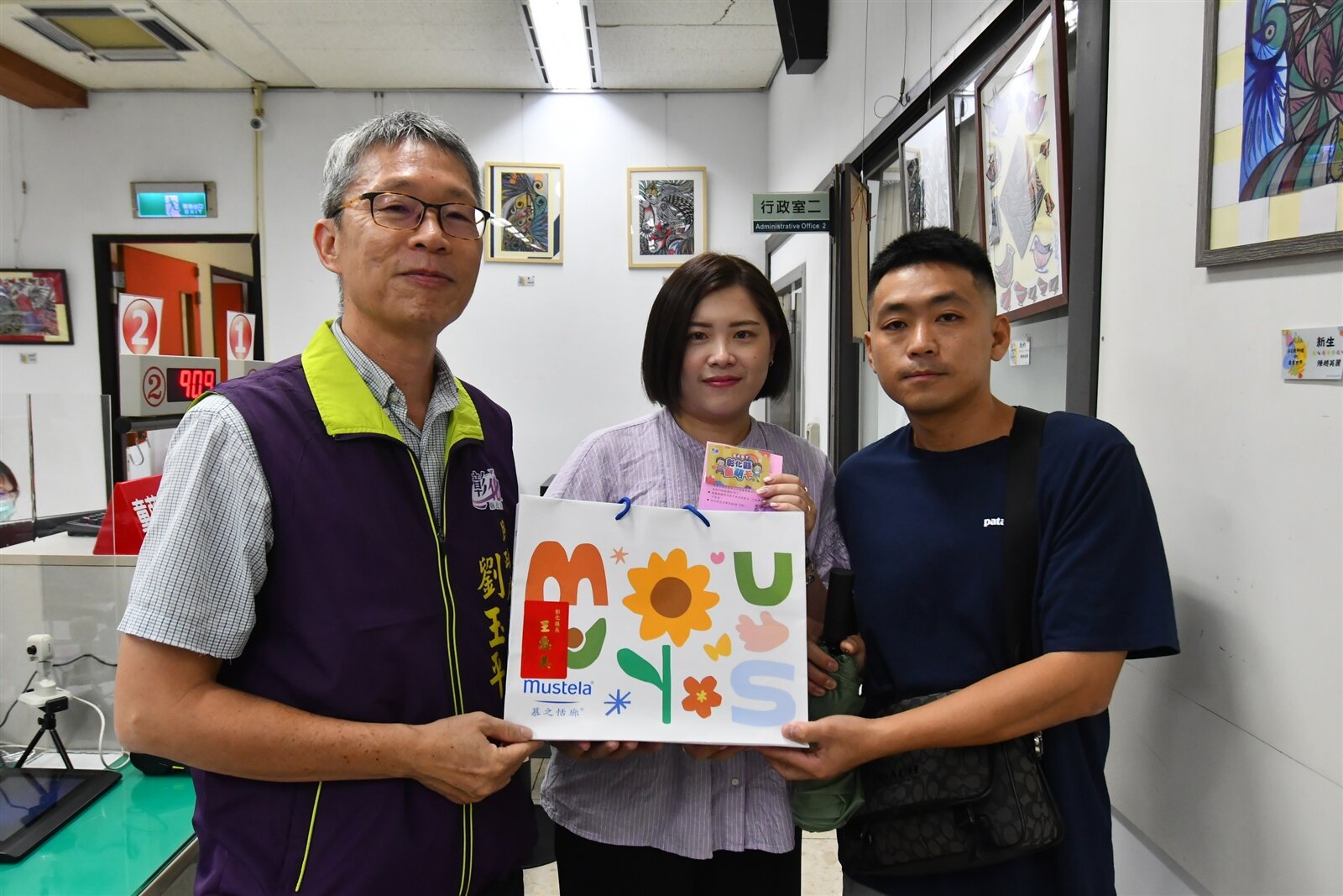 彰化縣推出全國首創彰化幼兒獨有的「童萌卡」,民政處長劉玉平(左)發卡給搶到「頭香」的王姓縣民夫婦。記者劉明岩/攝影