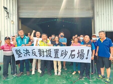 台中市大里區草堤路業者擬設砂石碎解洗選場,西湖里長賴加彬(前排右二)20日率居民拉白布條抗議。(潘虹恩攝)
