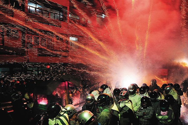 鹽水蜂炮昨天晚間熱鬧登場,吸引不少民眾全副武裝近距離體驗,現場火光四射百炮齊放場面震撼。 記者王騰毅/攝影