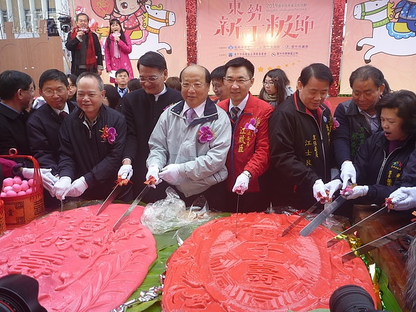 市長胡志強(中)與立委江啟臣等人士,將龜粄與桃粄切成小塊,分給現場的民眾品嚐。(記者黃玉鼎攝)