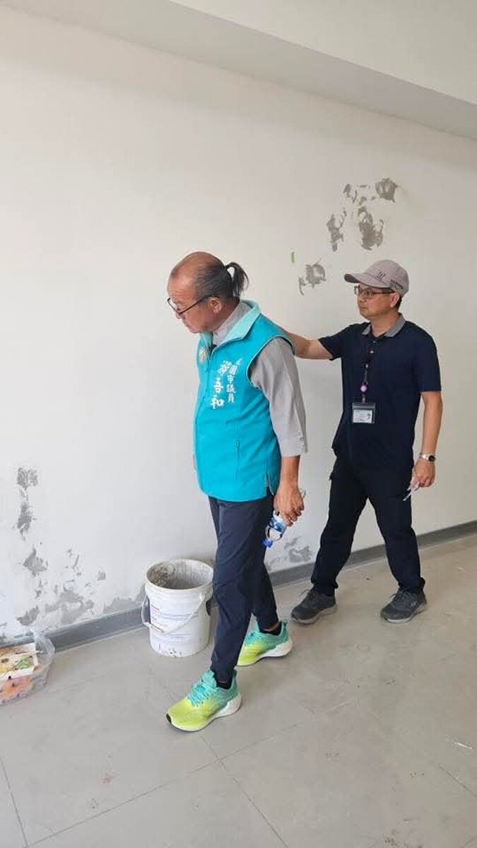 議員游吾檢查和了解牆壁油漆為何剝落，住宅處說明部分是已發現要求改善的缺失。圖／議員游吾和提供