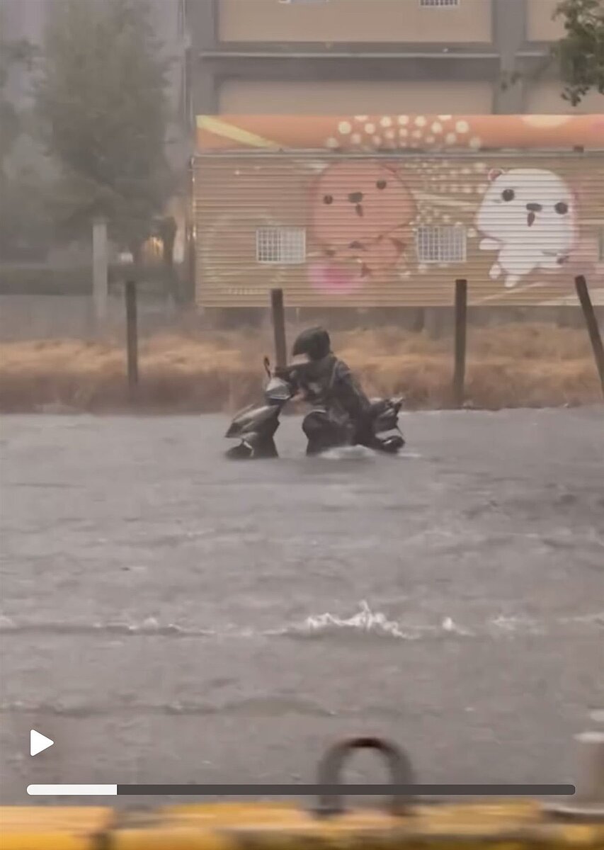 台中市西屯區台灣大道5日晚遭大雷雨狂炸變河道,一名機車騎士推車涉水前行。圖/翻攝自Threads@loewe2734