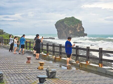 丹娜絲颱風逼近,墾丁著名景點船帆石6日一早仍有遊客觀浪。(羅琦文攝)