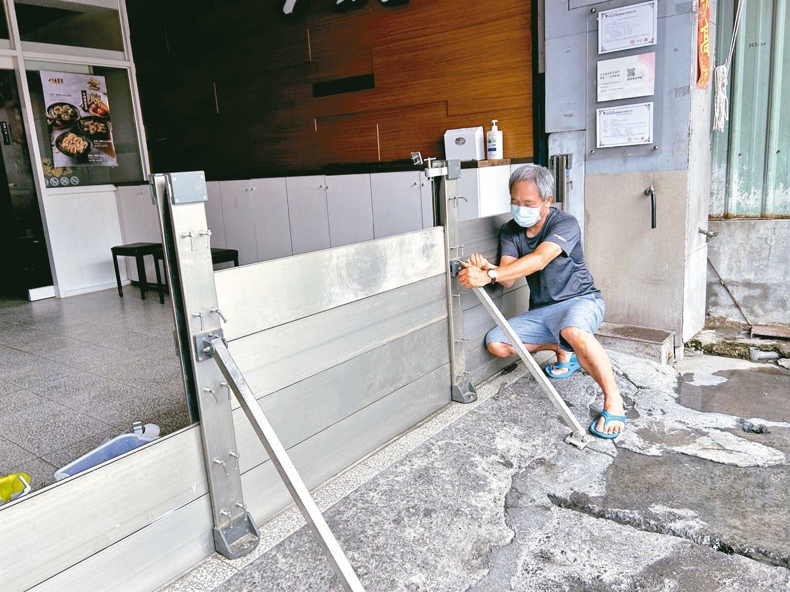 高雄美濃區的店家去年颱風時「淹怕了」，昨趕在大雨來襲前裝上防水閘門自保。記者徐白櫻／攝影 
