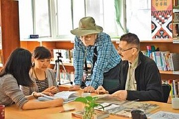 俄國人拉普汀(右一)和馬可夫(右二)造訪獅子鄉,鄉立圖書館長李秀娟(左二)協助比對老資料。(截取自獅子鄉公所)