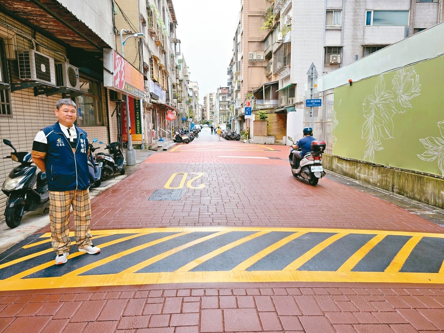 北市嘉興里長鄭智耀（左）說，瀝青減速丘可提醒車輛慢行、注意行人。記者邱書昱／攝影 