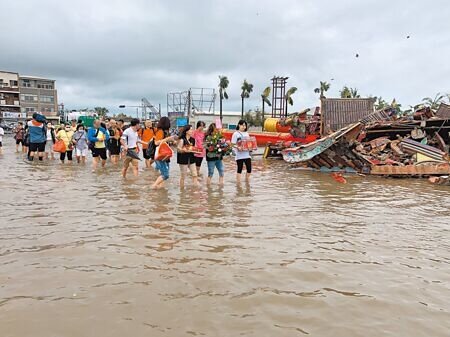 南鯤鯓代天府7日上午仍有進香團入廟朝拜,團員捧著神像涉水通過廟埕。(郭良傑攝)