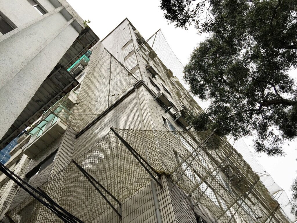 部分大樓外牆因磁磚掉落架設防護網,不僅不美觀,也只是治標不治本。