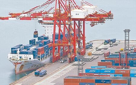 美國總統川普宣布14國的關稅稅率,台灣未列首波名單引發憂慮,行政院表示談判團隊仍續與美協商。圖為在基隆港內,碼頭作業人員正在裝卸貨櫃。(范揚光攝)