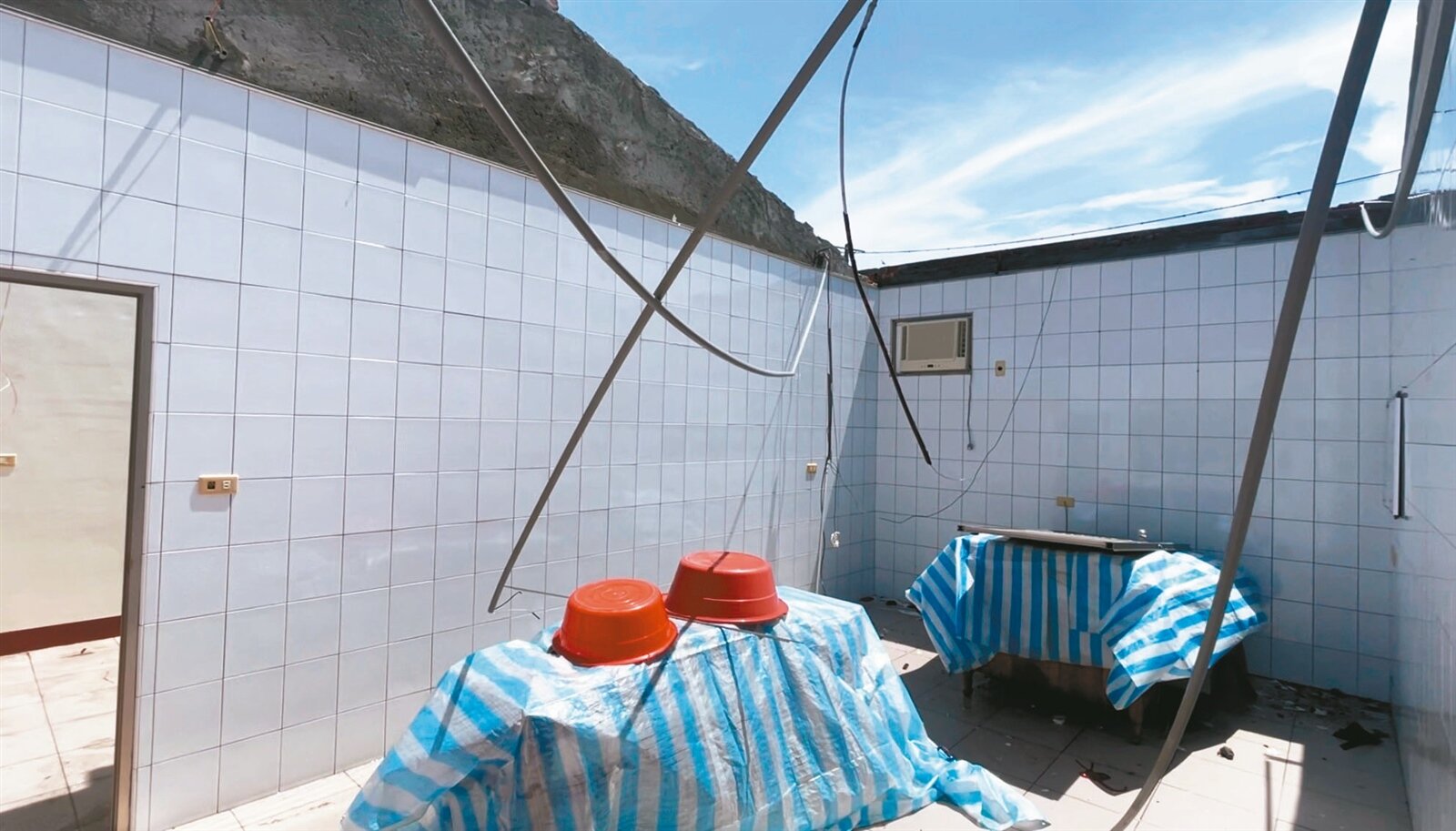 周姓受災戶住家屋頂直接被颱風吹走,讓她無奈說,民宅真的直接變「透天」。記者萬于甄/攝影