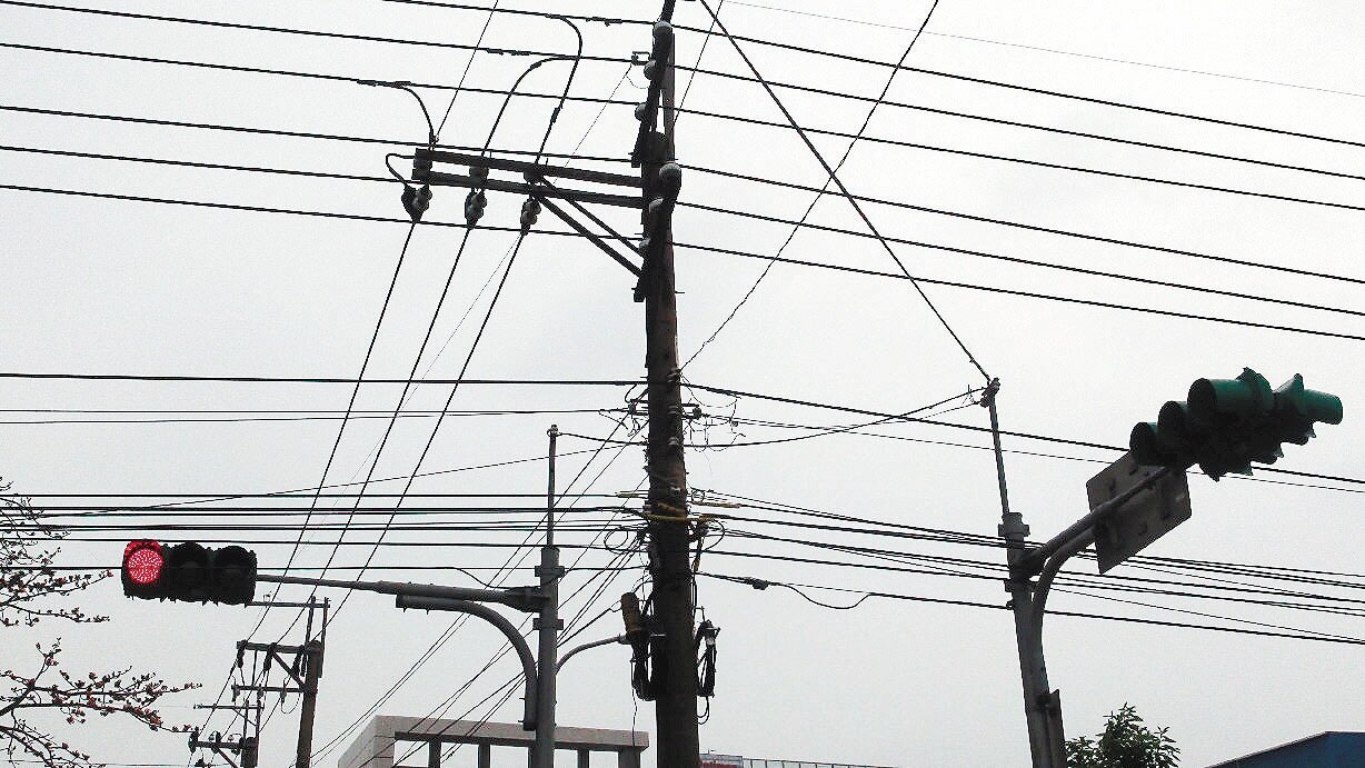 平鎮市平東路等路旁電桿上,出現很多單位自行加掛的架空電纜線,安全堪虞,甚至威脅用路人安全。 記者劉愛生/攝影