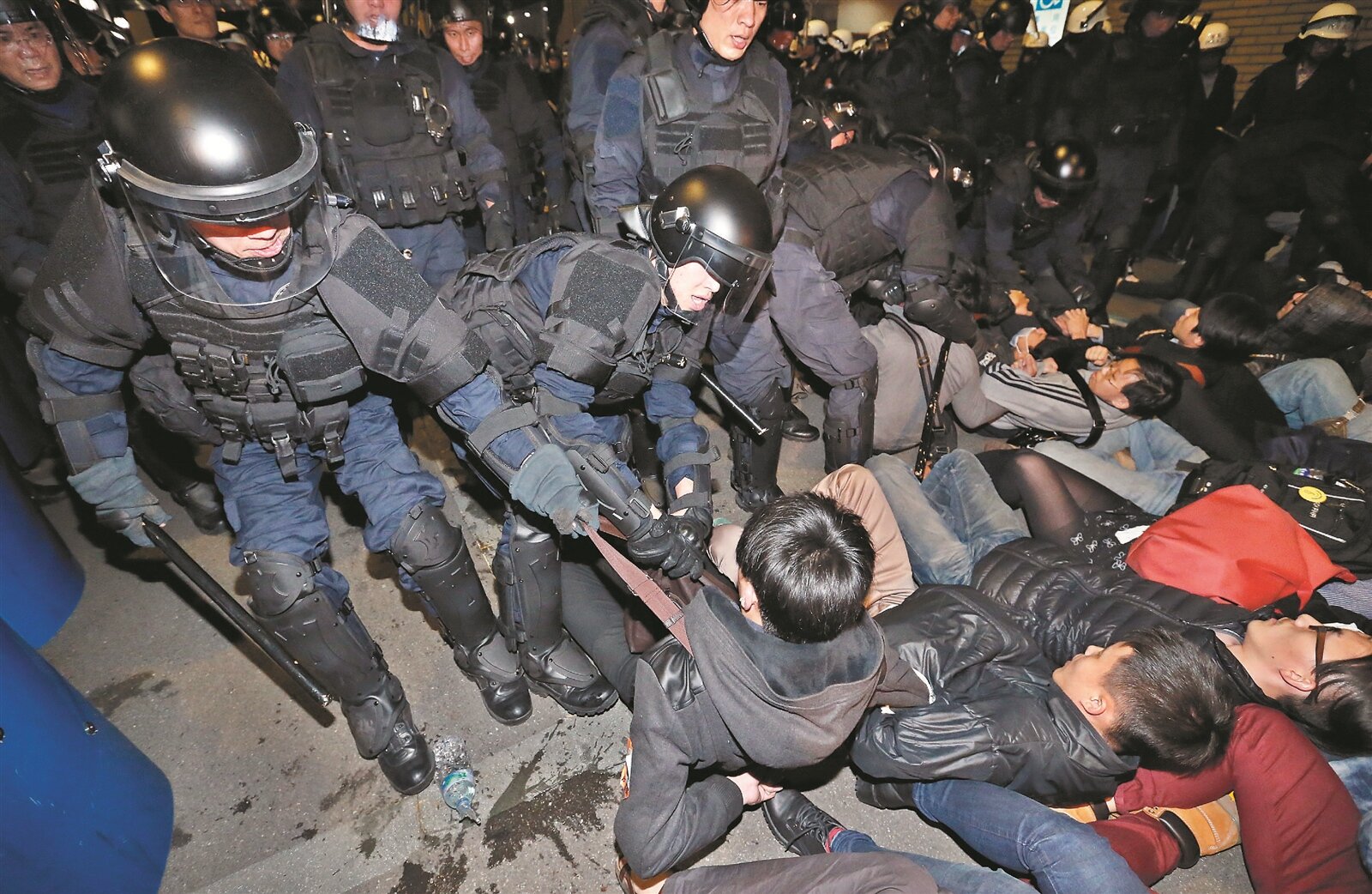 攻占行政院的反服貿學生凌晨被驅離，警方以優勢警力將躺在地上的學生一一拖離現場。 記者鄭超文／攝影