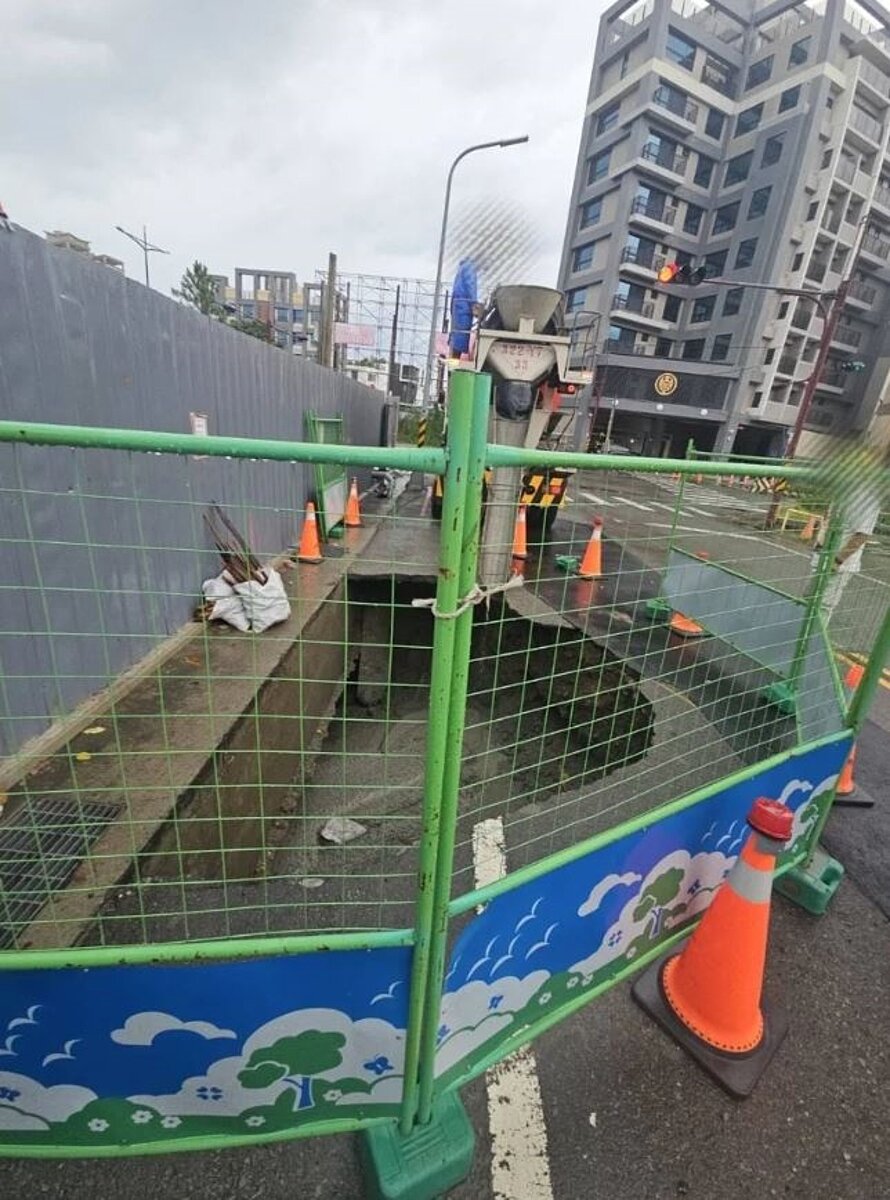 颱風丹娜絲過境,苗栗縣頭份市案一處地上14層、地下3層集合住宅建案旁道路,7月9日坍陷坑洞,縣府勒令停工。圖/頭份警察局提供