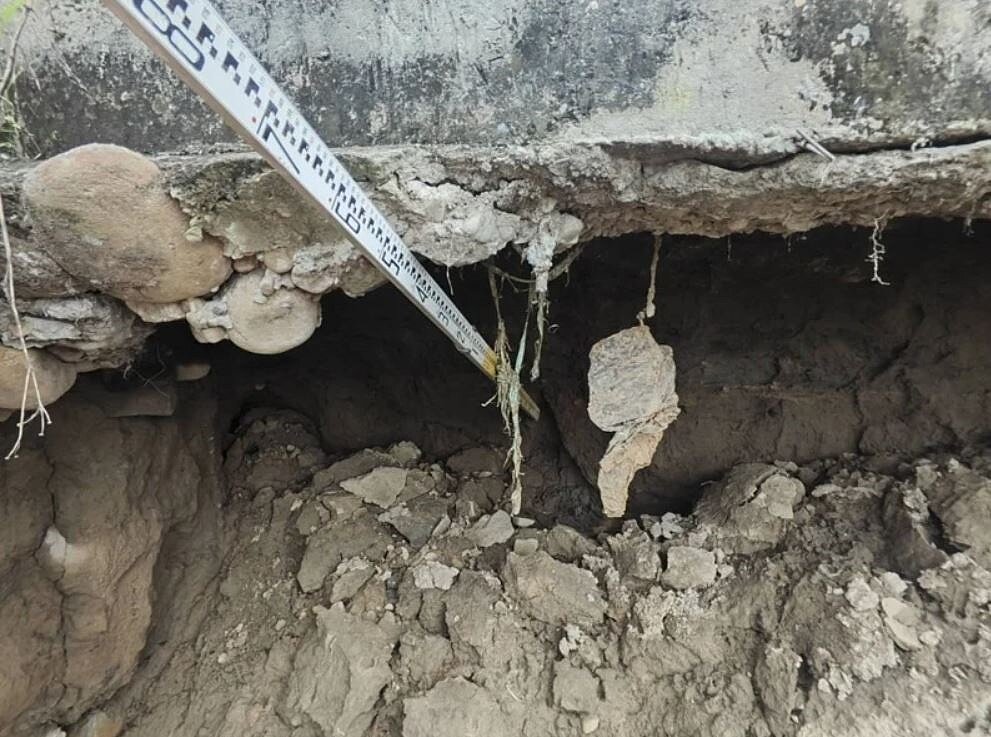 台中市龍井區安良港大排旁道路昨疑因遭洪水沖刷造成路基掏空,市府水利局派出工程人員搶修,初步已以太空包回填加固,避免災情擴大。圖/台中市政府提供