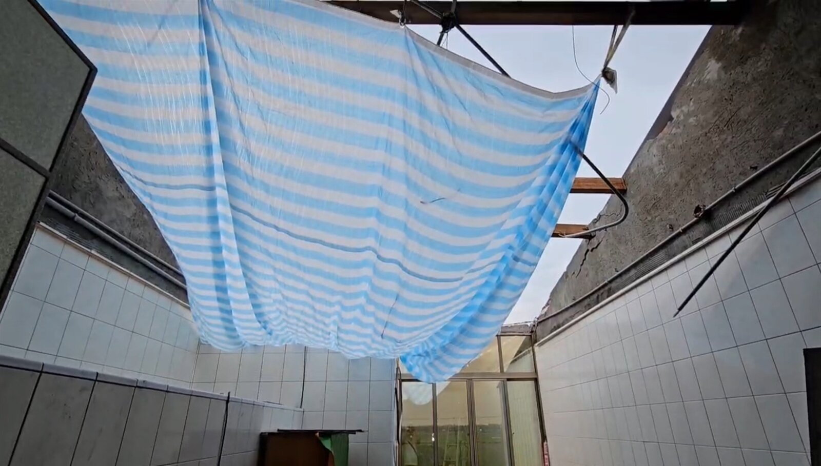 台南學甲區陳姓受災戶上網找工人想修繕屋頂卻遭詐騙,他因住家屋頂鐵片還掛在上面,就怕風一吹會砸到別人,希望趕緊處理。記者萬于甄/攝影