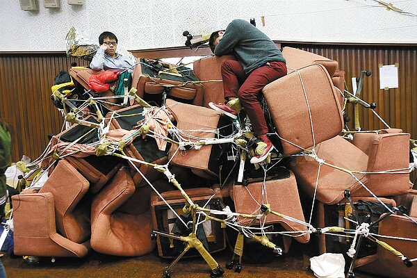 反黑箱服貿學生占領立法院議場上午進入第五天,行政院長江宜樺下午將出面與學生展開對話。堅守議場的學生們也累了,有人守在門障堡壘休息片刻。 記者曾吉松/攝影