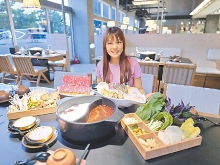 冒香香總經理李婕絲於台中旗艦店展示招牌「白米粥底+麻辣鍋」雙鍋組合,搭配現殺鮮魚、鮑魚等頂級新鮮食材,主打健康無負擔的火鍋體驗。圖∕王妙琴
