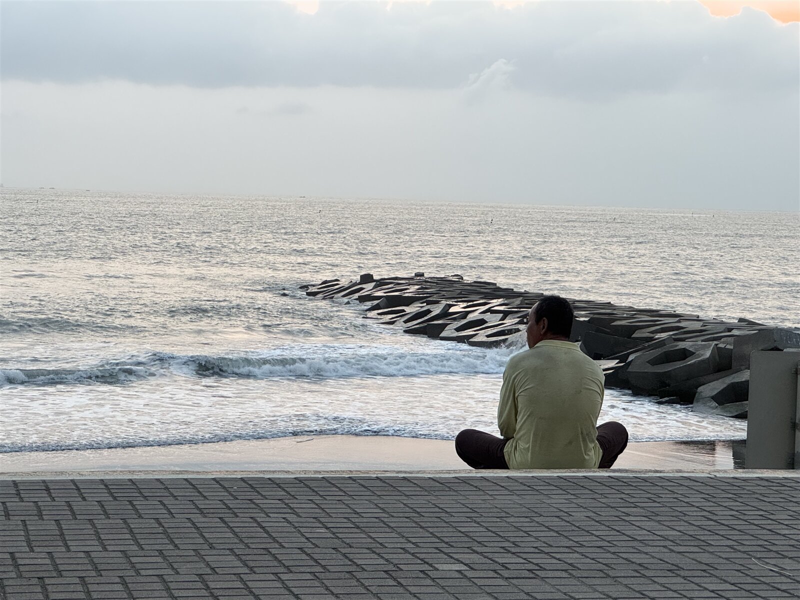 鍾父獨自坐在岸邊,落寞地望向海面,只希望盡快找到兒子的下落。記者邵心杰/攝影