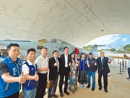 桃園市文化局修復市定古蹟「前空軍桃園基地05警戒區」4座機庫及1棟警戒室,打造「航空城博物館園區」,24日開館試營運,首度對外展示。市長張善政(左五)等人身後是F-104G戰鬥教練機。(廖姮玥攝)