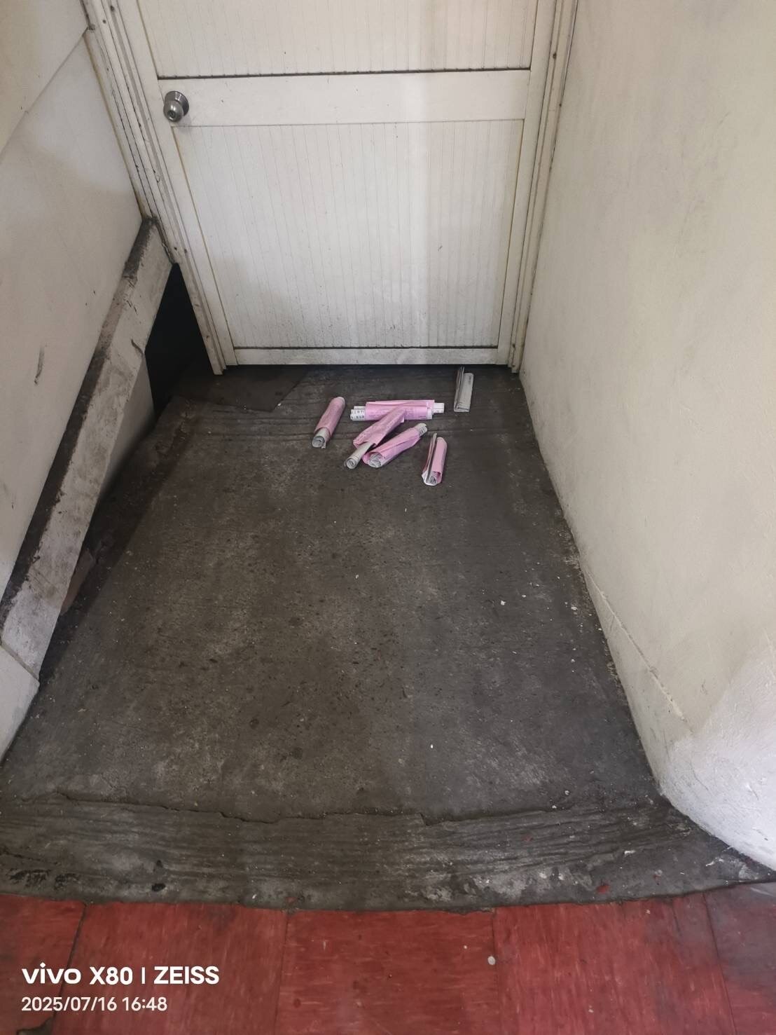 有不明女子趁里鄰長投遞完投票通知單後,潛入大樓信箱區,將通知單抽出並直接丟棄在地。圖:余信憲提供