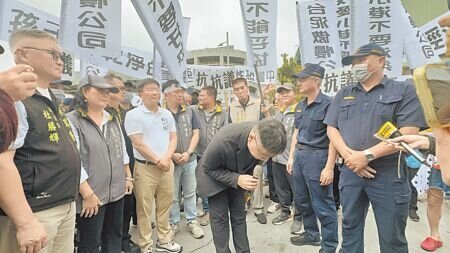 台泥旗下三元能源公司鋰電池工廠14日發生火災,引發安全疑慮,300多位在地居民於30日在廠區大門前拉起白布條抗議,要求遷廠。三元能源總經理薛人禎(中)出面鞠躬致歉,並接過抗議書。(洪靖宜攝)