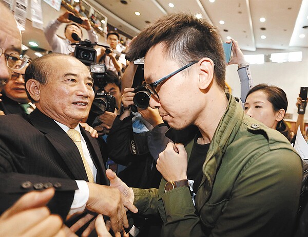 立法院長王金平上午從目前唯一可通行的窄門進入立院議場內探視學生,學生代表林飛帆(圖右)在門口與王金平握手。 記者鄭超文/攝影