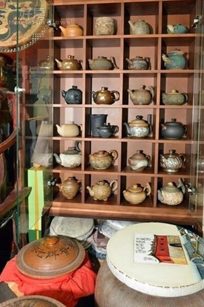 
3.牆上木櫃裡收藏著臺灣知名陶藝家的創作茶壺。