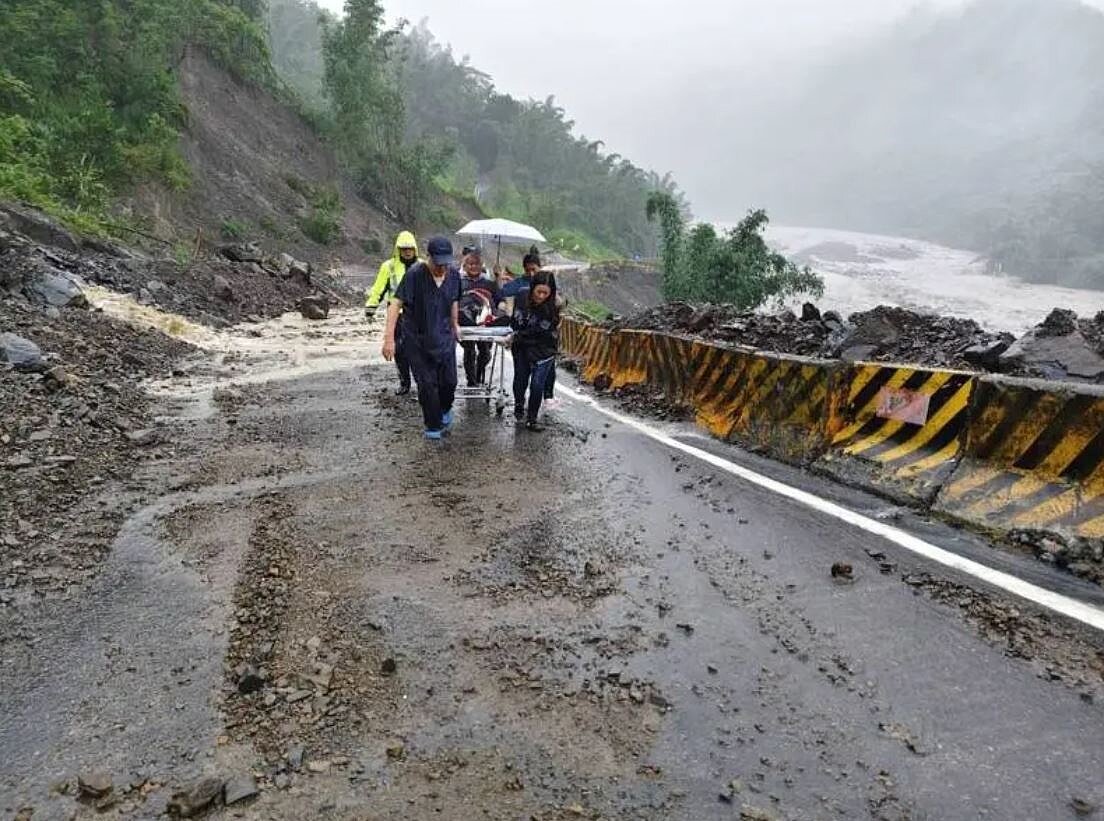 高雄那瑪夏交通中斷，醫護人員徒步接力送腹痛病患下山撐起隱形橋梁。圖／高雄榮總提供
