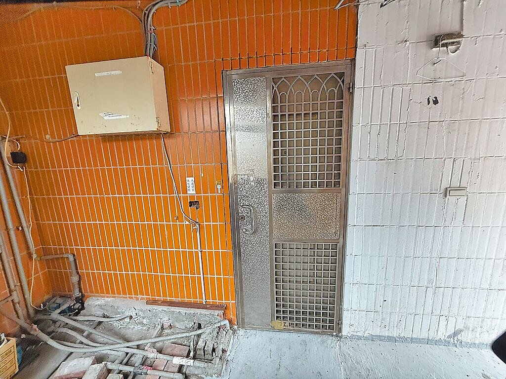 新北市工務局4日派員前往淡水新民街公寓勘查,但大門深鎖無人回應。圖/新北市工務局提供