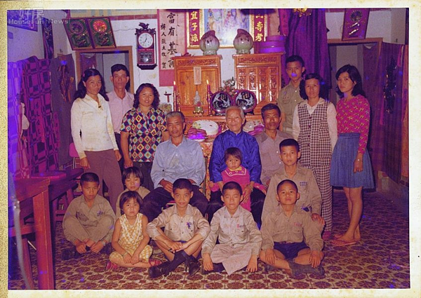 1、外婆70大壽時家族合影(著藍衣坐者),中間穿黑鞋黑襪、盤腿而坐者是吳鈞堯,右側是弟弟。後排最左,長髮、皮膚略黑的女人是母親。其旁兩頰凹瘦者是父親。他的大哥、三個姊姊,都不在照片裡,彼時已在台灣南崁車床工廠做工賺錢了。